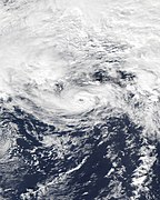 A cyclone with banding clouds wrapping cyclonically over its center; a small eye can be seen in the center of the storm