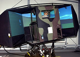 A soldier tests out a heavy-wheeled-vehicle driving simulator.