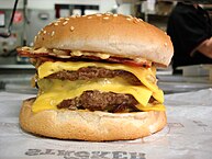 A Burger King "Quad Stacker" cheeseburger, containing four patties and bacon
