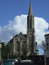 Façade of church seen from the northwest. The façade, west tower, and spire are all that remain of the church built in 1878.