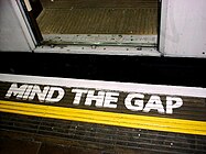 Warnung „MIND THE GAP“ auf der Bahnsteigkante einer Station der London Underground