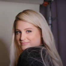 Meghan Trainor, a woman, smiling and looking towards the screen