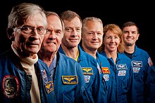 Photograph of Young and Crippen standing in a row with the crew of STS-135