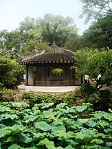 A pavilion with a fan-shaped viewing window in the pond of the Humble Administrator's Garden in Suzhou