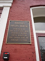 Memorial Plaque on the present day building occupying the site of the former Rhoads Opera House Building
