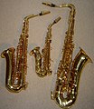 Comparison in size of a curved B♭soprano saxophone (centre), an E♭alto saxophone (left), and a B♭tenor saxophone (right)