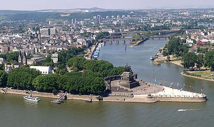 high angle view the confluence of two major rivers, marked by the statue of a man on a horse, with a city behind