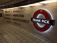 Words mounted on a cream-coloured stone wall next to a large, illuminated London Underground symbol (red ring with a blue bar) with the words "Frank Pick" on the blue bar