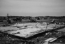 Black and white photo of the remaining foundation of a destroyed home.