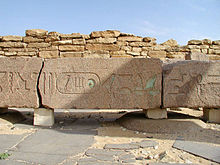 Enormous beam of granite with large hieroglyphs on it, some of which are still green
