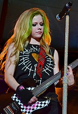 Avril Lavigne plays guitar at a concert