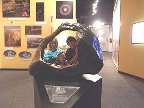 Children posing behind the Tucson Meteorite at the Arizona Museum of Natural History