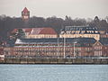 Die beiden weißen Gebäude der Tirpitz- und Maaß-Kaserne in der zweiten Reihe von der Wasserseite aus.