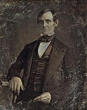 Middle-aged clean-shaven Lincoln from the hips up.