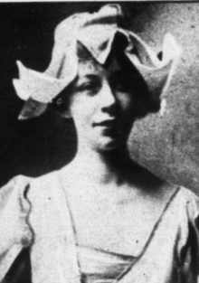 A young white woman wearing a hat with multiple turned-up peaks around the brim