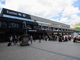 Side on view of a station entrance with a statue