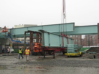 A large steel beam being lifted onto a viaduct