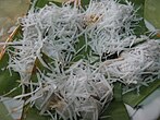 Mont lone yei baw – glutinous rice balls filled with jaggery, covered with shredded coconut – a New Year treat