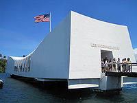 White Arizona memorial with downward sloped top and American flag