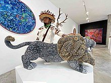Huichol artist with a big lion sculpture covered with crystal beads.