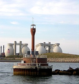 Deer Island Light in 2009, with Deer Island Waste Water Treatment Plant digesters in the background.