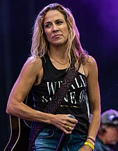 Sheryl Crow playing guitar onstage