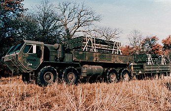 An early promotional image of a M977 HEMTT and trailer; payload are MLRS reloads