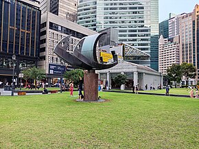A brass sculpture in a shape of a ship in a clearing outside of the station