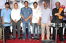 Nani, Sanjeev Lamba, Ajay Devgan, Rajamouli, Keeravani and Suresh Babu stand and look towards the camera.
