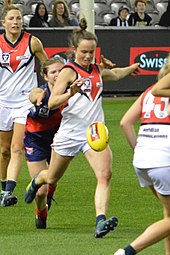 Pearce kicking the ball under pressure from an opponent