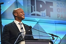 Governor Wes Moore smiling at a podium at the International Offshore Wind Partnering Forum