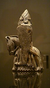 Photograph of an ivory gaming piece depicting an armed warrior on horseback