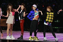 The group onstage, striking individual poses