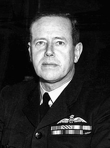 Head-and-shoulders portrait of man in dark military uniform with ribbons and pilot's wings on chest