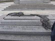 A granite tomb engraved with The Unknown Soldier on the side; a bronze relief sculpture is atop the sarcophagus