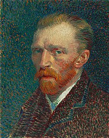 A head and shoulders portrait of a thirty-something man, with a red beard, facing to the left
