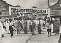 Group of people marching with a banner in Chinese and English