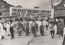 Group of people marching with a banner in Chinese and English