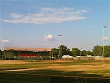 View of a grandstand and baseball field from the furthest point of the outfield
