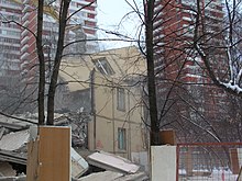 The remains of a low rise building are seen between two high rises