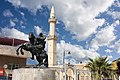 A statue of Saladin and mosque behind in the city center