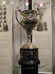 Silver bowl trophy with two large handles, mounted on a black plinth