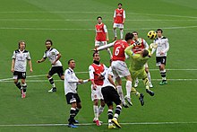 North London derby at the Emirates, Koscielny attempting to head the ball with goalkeeper Gomes reaching for it while other players look on