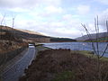 Image 13At the Rhodeswood reservoir dam, we see the outflow canal from the Torside Reservoir dam, alongside the Rhodeswood Reservoir. The Torside dam can be seen in the distance. To the right is Shining Clough Moss and Bleaklow. To the left Bareholm Moss and Black Hill (from Longdendale Chain)