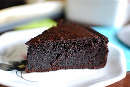 A slice of flourless quinoa chocolate cake on a white plate