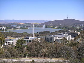 Series of modern buildings in front of a lake and mountains