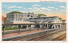A postcard view of railway station platforms and a large brick station building