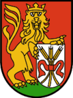 Wappen der Marktgemeinde Lustenau mit einem gekrönten, auf den Hinterbeinen stehenden Löwen, der zwischen seinen Vorderpranken ein silbernes Schild hält, auf dem drei mit einer roten Schleife zusammengebundene Ähren abgebildet sind.