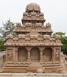 Stone temple, with rocks in front and another temple on the left