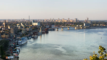 Panoramic view of Kyiv riverfront, with boats and a bridge